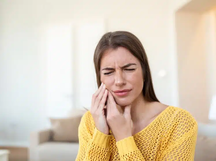 Woman experiencing gum inflammation pain, seeking gum inflammation treatment